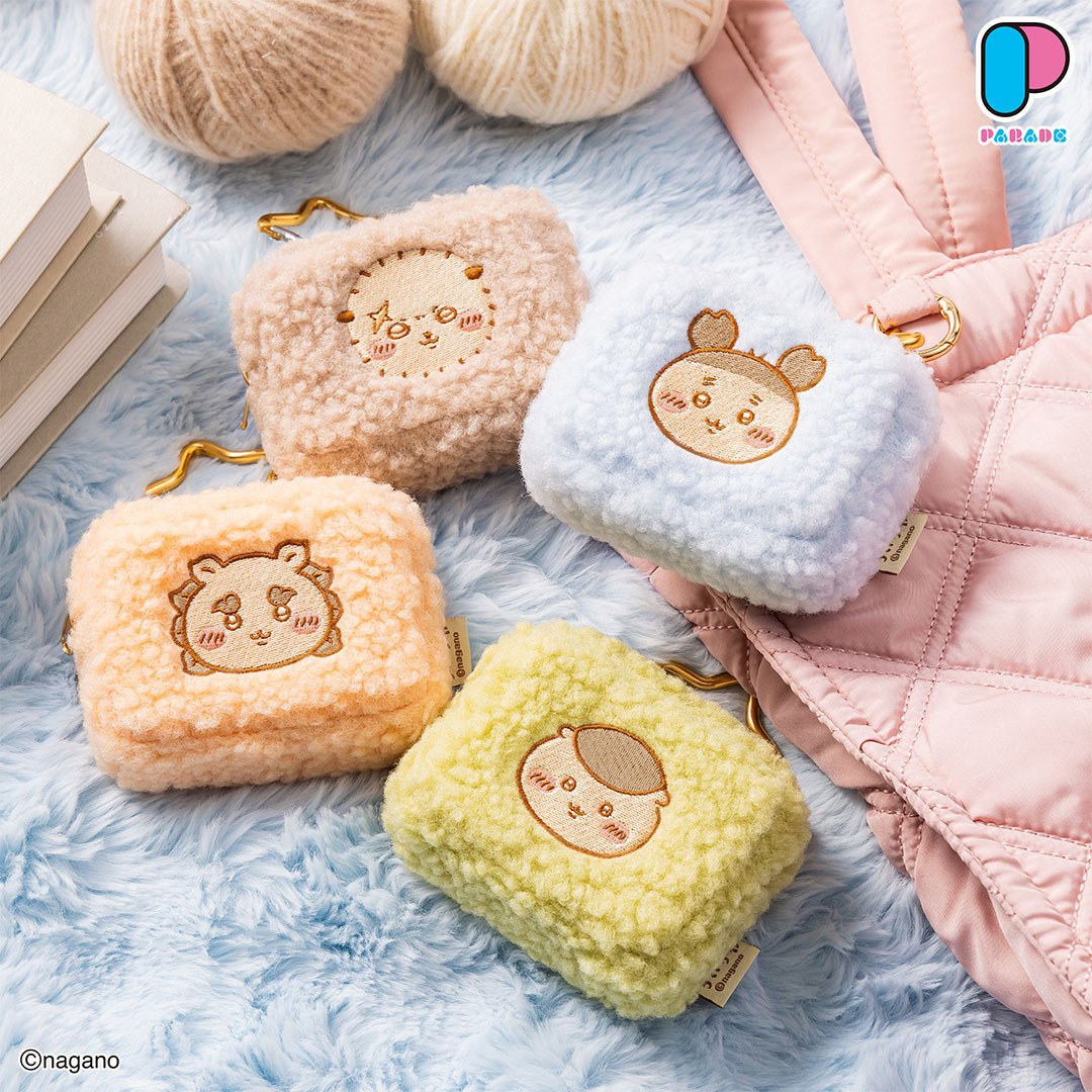 Four more Chiikawa fluffy pouches in beige, sky blue, apricot and pale yellow-green on a blue faux-fur throw beside a pink quilted bag
