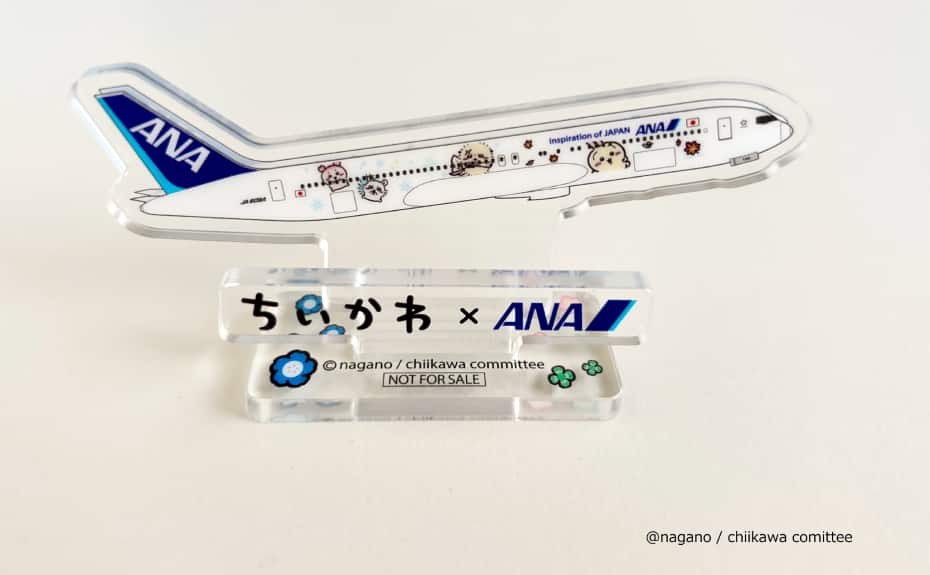 Reverse side of the Chiikawa × ANA acrylic stand prize showing the jet’s tail and more Chiikawa characters