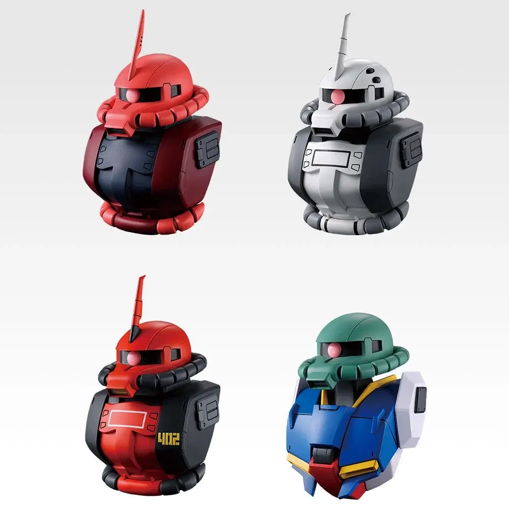 Four E prize Zaku head magnets: a red commander Zaku, a white and grey Zaku, a red and black Zaku numbered 402 and a green Zaku head on a Zeta Gundam body