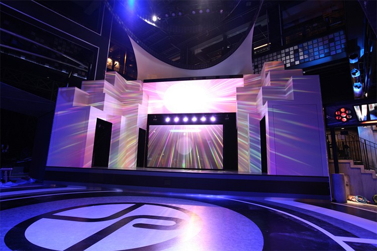 The Tokyo Joypolis 1st Floor main stage lit in purple and pink, with a large screen at the centre and the Joypolis logo on the floor