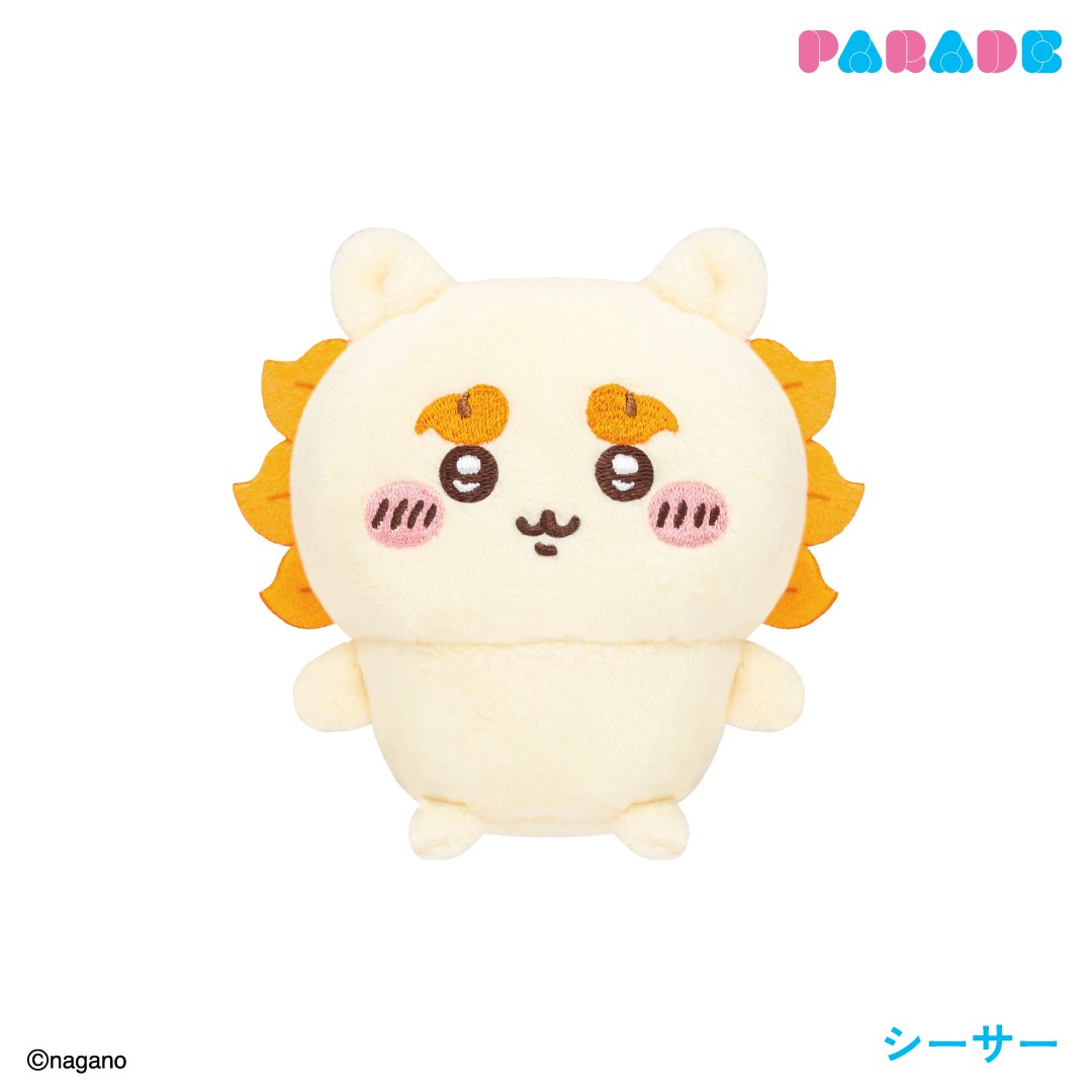 Shisa sitting plush in pale yellow with an orange lion-like mane, round ears and pink cheeks on a white background