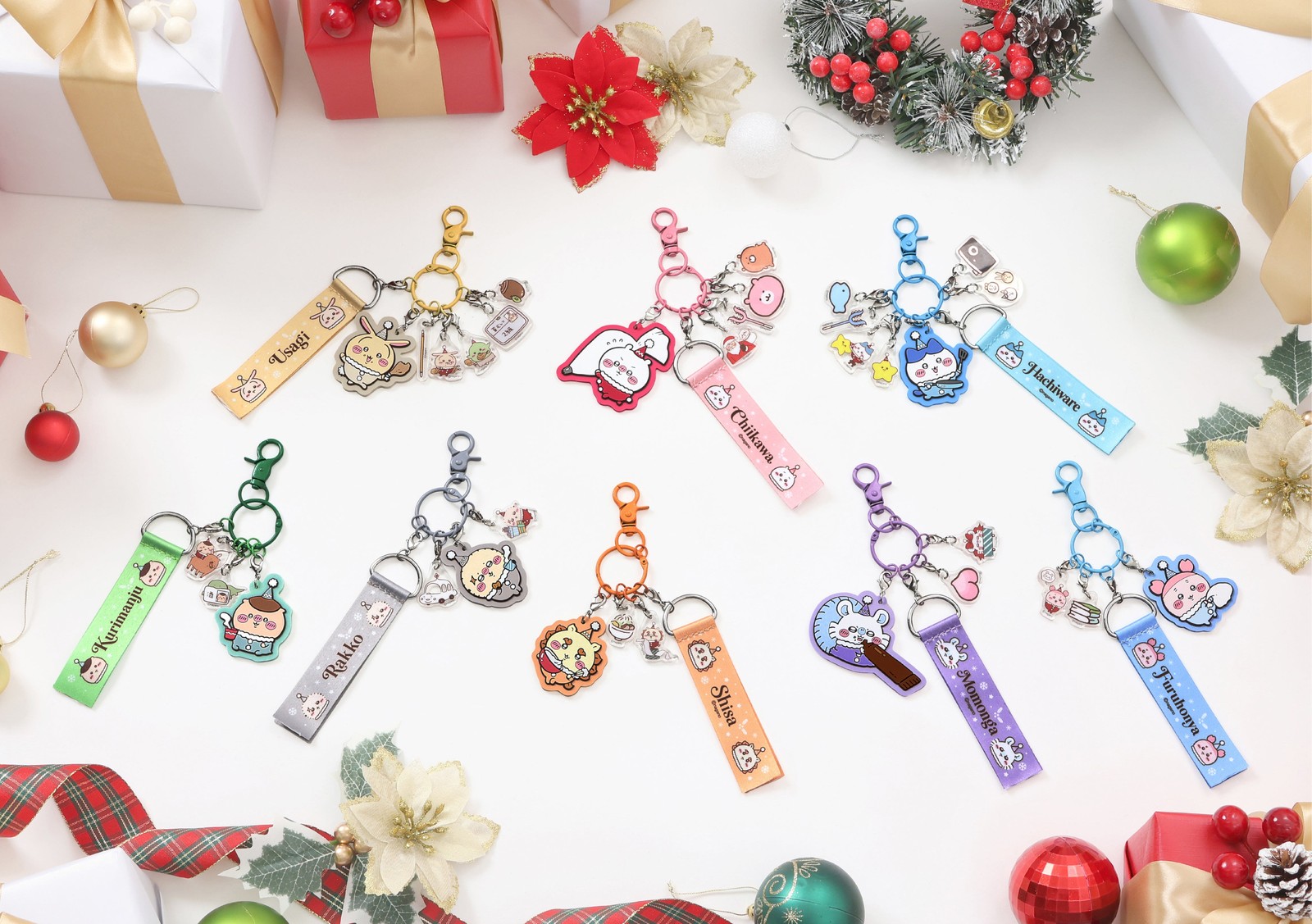 Eight Christmas-themed Chiikawa acrylic key charms with colour-coded straps laid among baubles and gift boxes