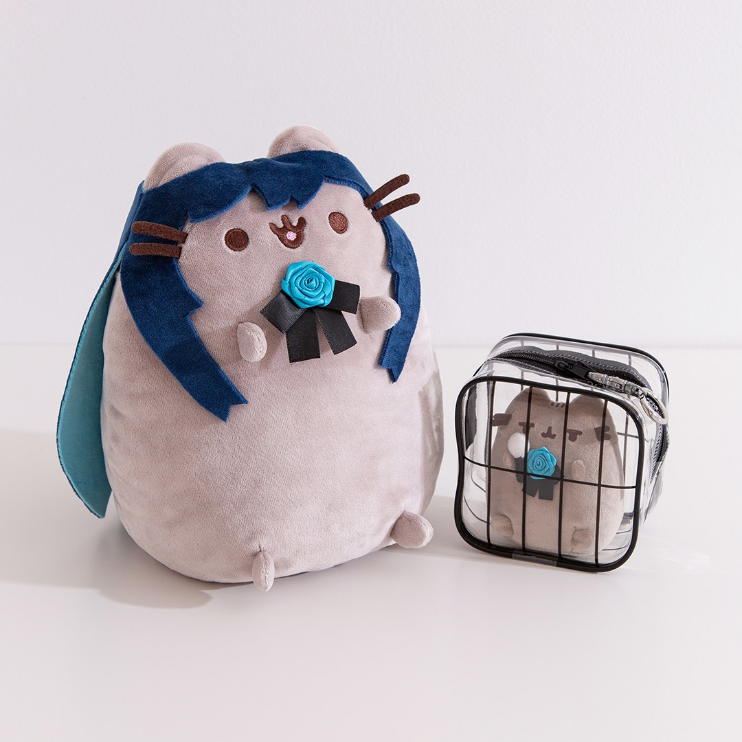 Ado x Pusheen collaboration plush with blue hair and rose next to a clear travel case