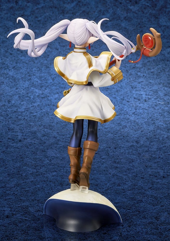 Back view of the Frieren figure showing her twin tails spreading outwards, the back of her white capelet and the staff head rising over her shoulder above the moon base