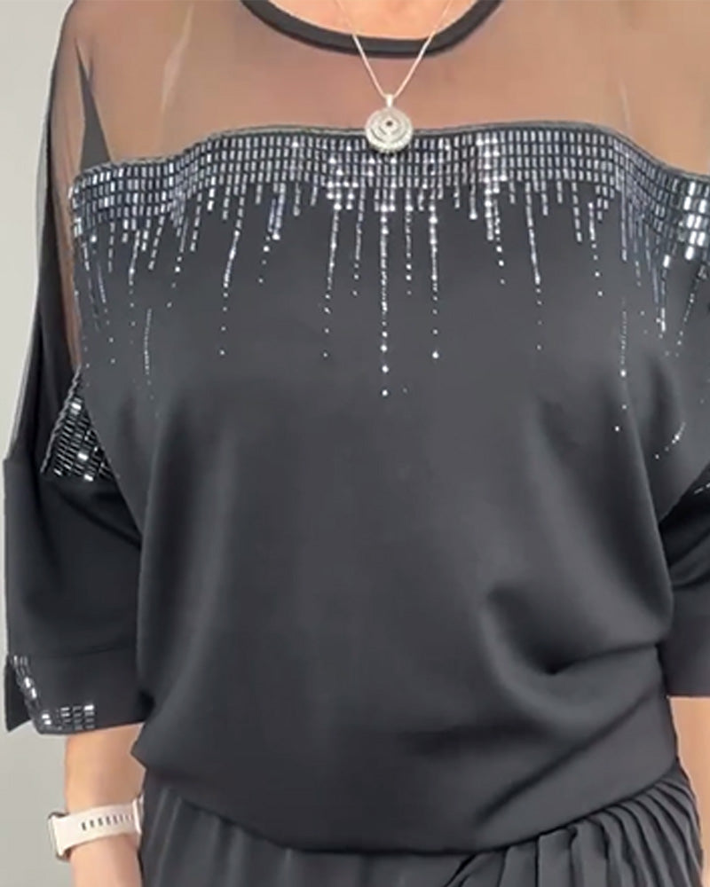 třásněný síťovaný top a plisované kalhoty s širokými nohavicemi