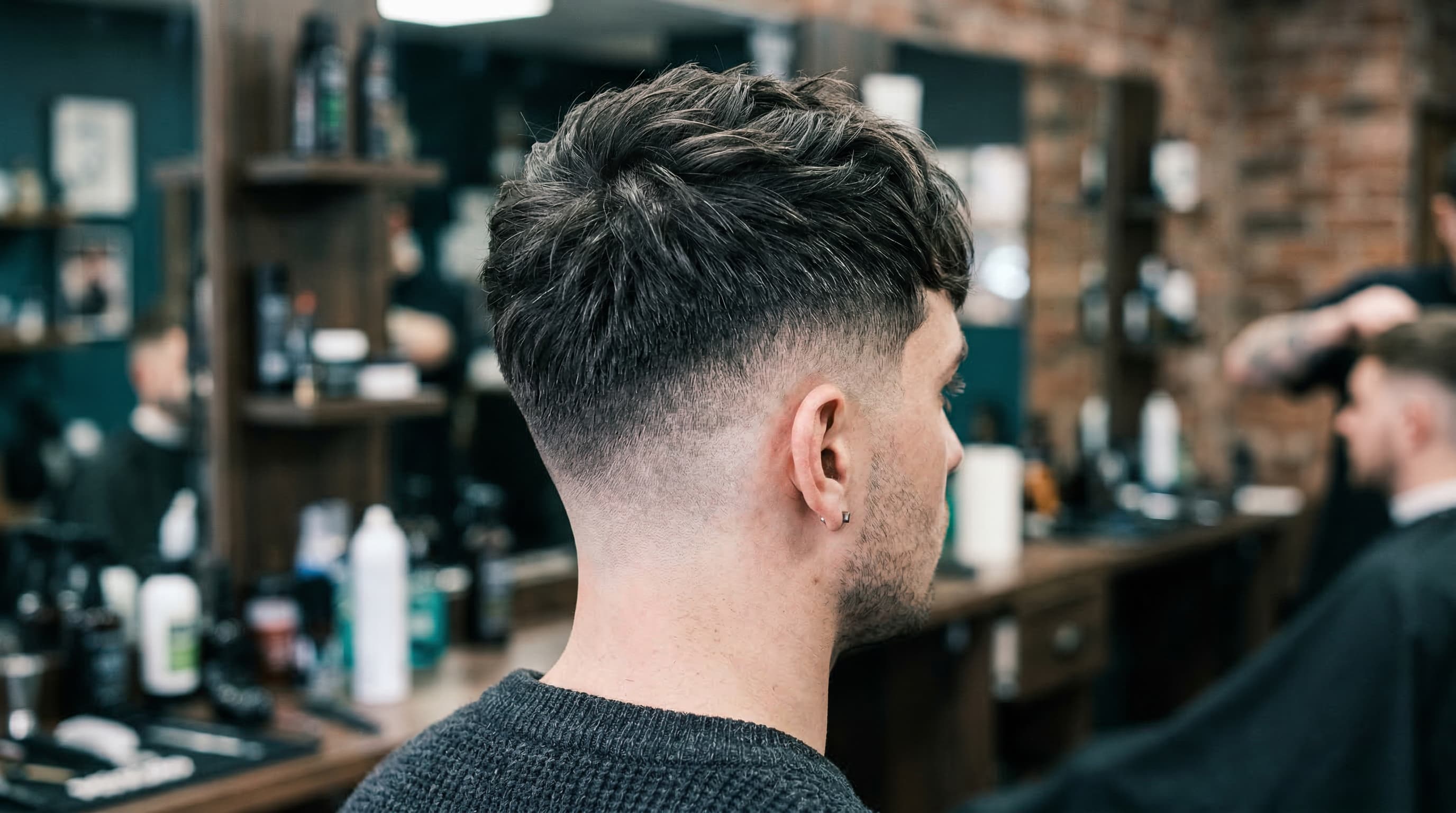 Textured French crop haircut with faded sides and messy fringe men's barbershop style