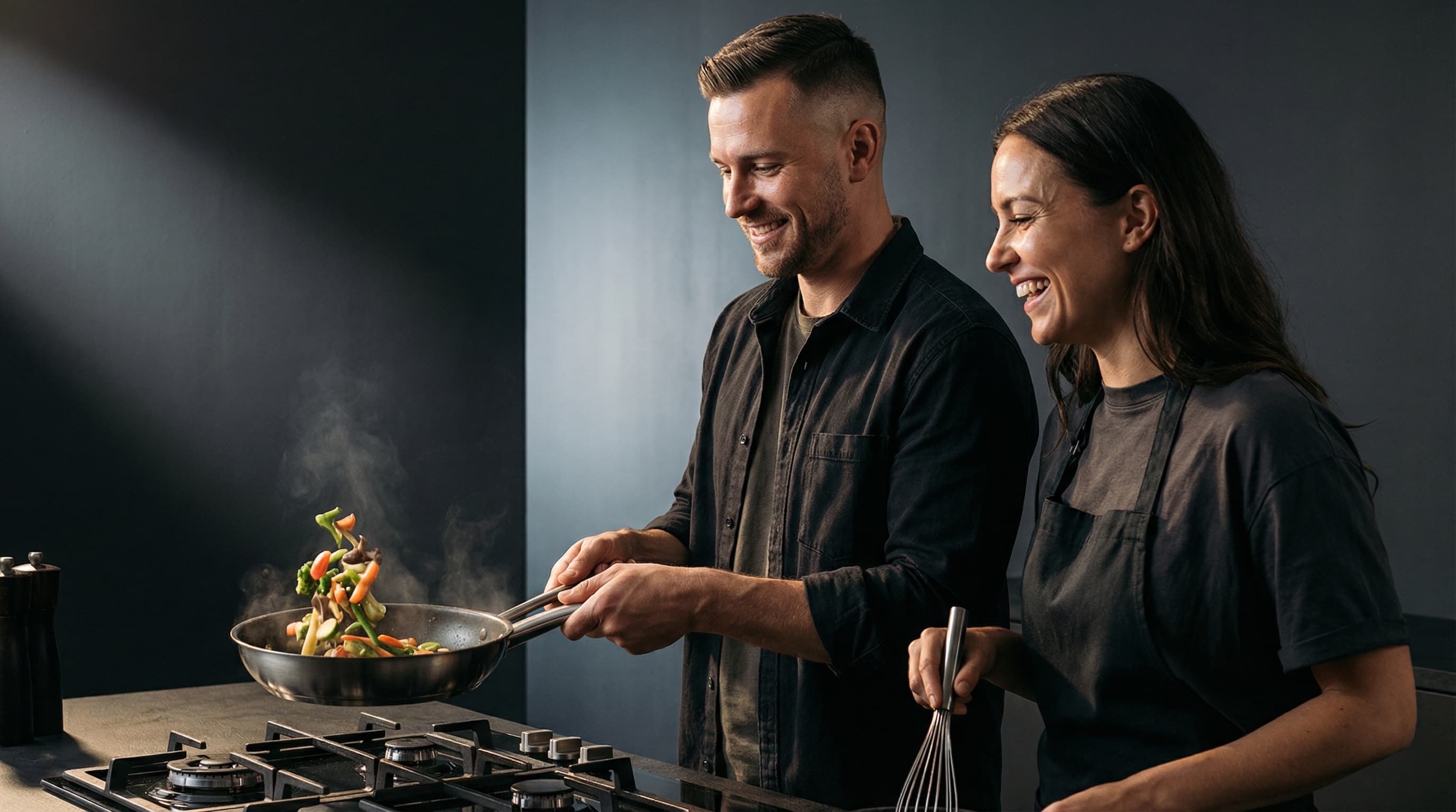Happy couple cooking together in kitchen showing men's attractive cooking skills