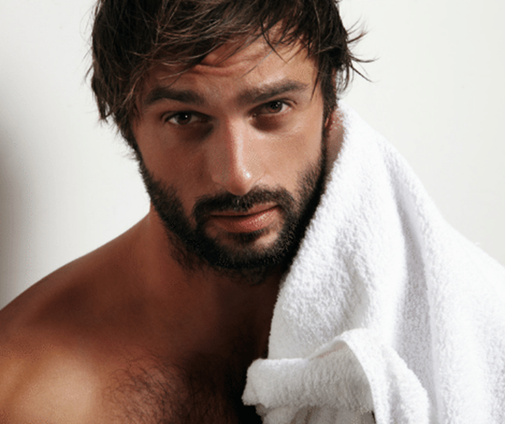 Sexy hairy man towel drying his damp hair after a shower