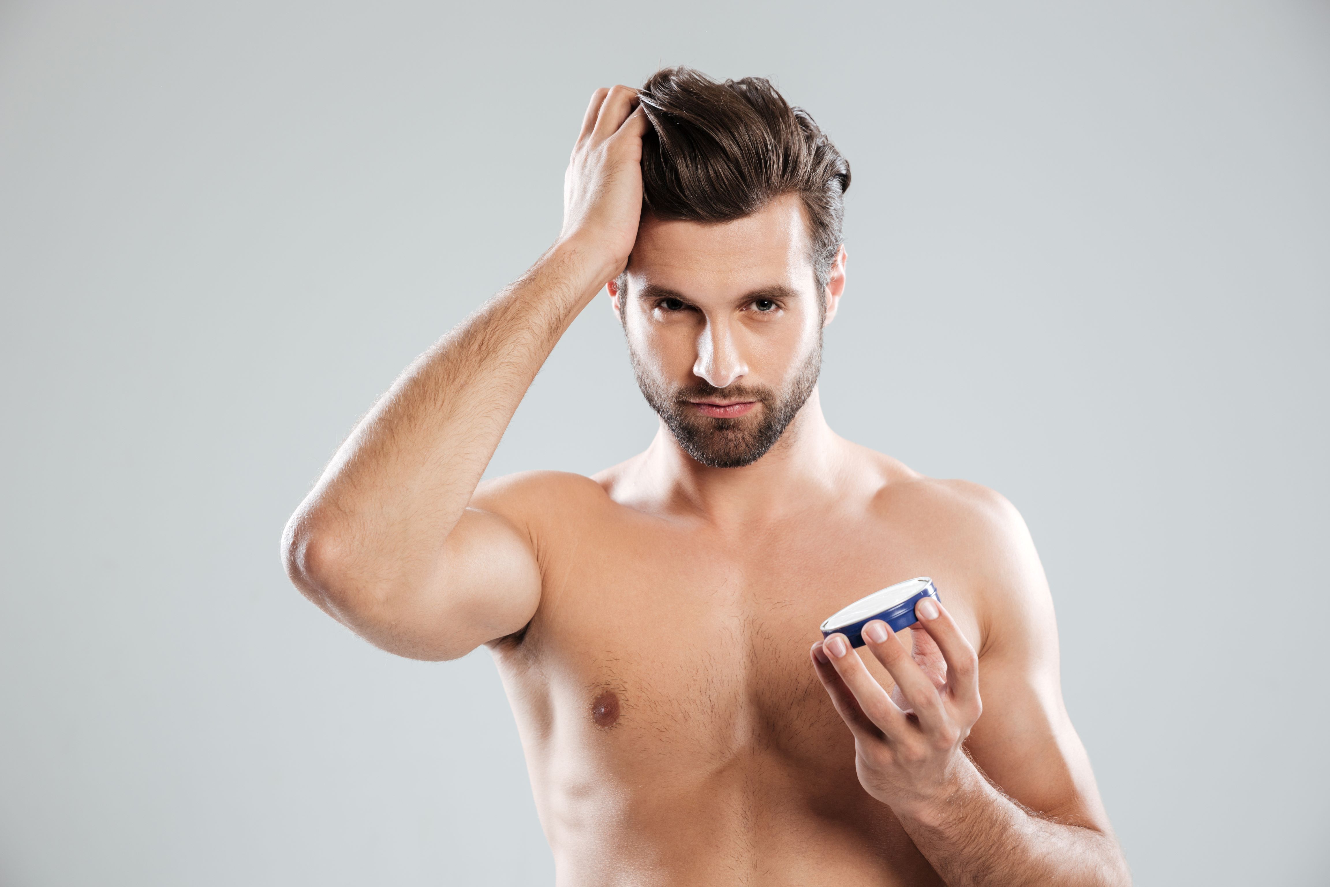 Young man holding hair wax jar - hair styling product for men