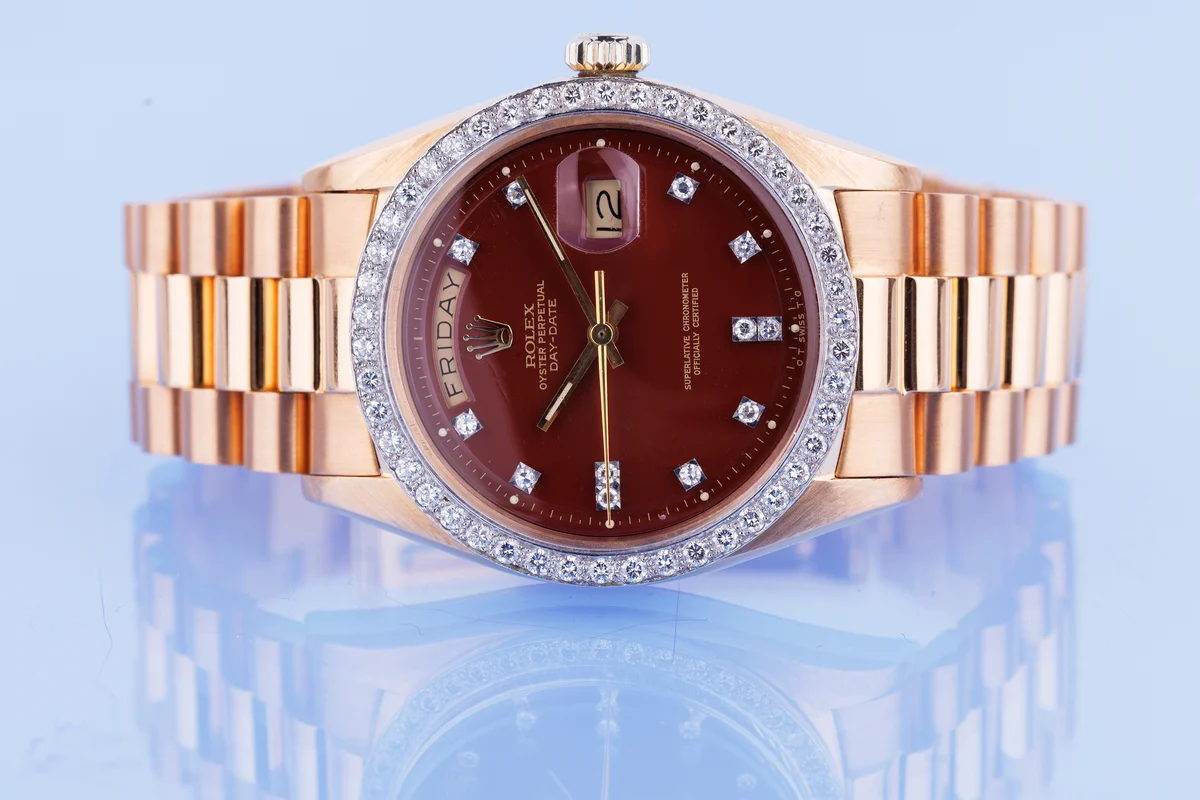 Rolex Day-Date | Ref. 1804 | Quadrante bordeaux “Stella” | Rari doppi indici con diamanti e lunetta con diamanti | Oro rosa e oro bianco 18 carati | 1973 ([Chrono24][1])  [1]: https://www.chrono24.com.au/rolex/day-date--ref-1804--oxblood-red-stella-dial