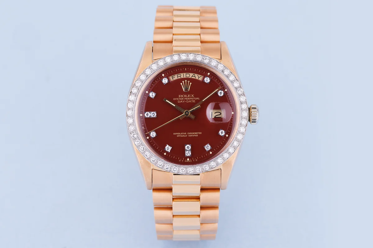 Rolex Day-Date | Ref. 1804 | Quadrante bordeaux “Stella” | Rari doppi indici con diamanti e lunetta con diamanti | Oro rosa e oro bianco 18 carati | 1973 ([Chrono24][1])  [1]: https://www.chrono24.com.au/rolex/day-date--ref-1804--oxblood-red-stella-dial