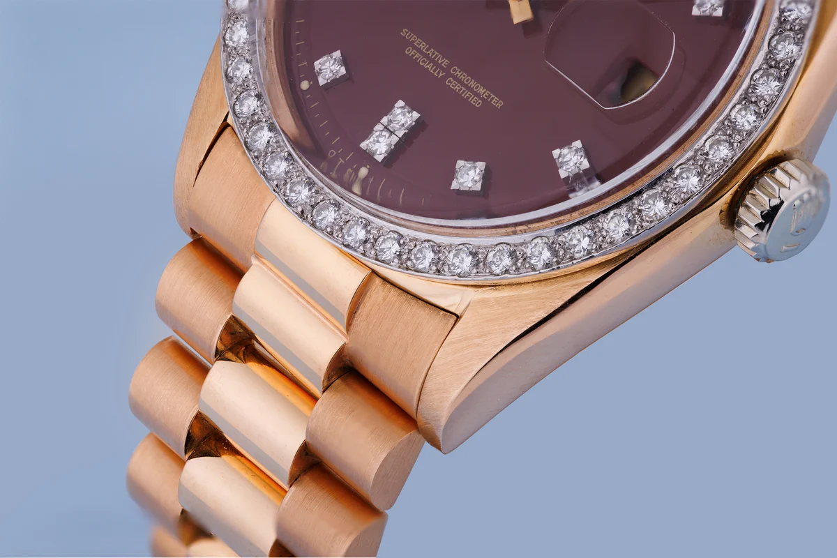 Rolex Day-Date | Ref. 1804 | Quadrante bordeaux “Stella” | Rari doppi indici con diamanti e lunetta con diamanti | Oro rosa e oro bianco 18 carati | 1973 ([Chrono24][1])  [1]: https://www.chrono24.com.au/rolex/day-date--ref-1804--oxblood-red-stella-dial