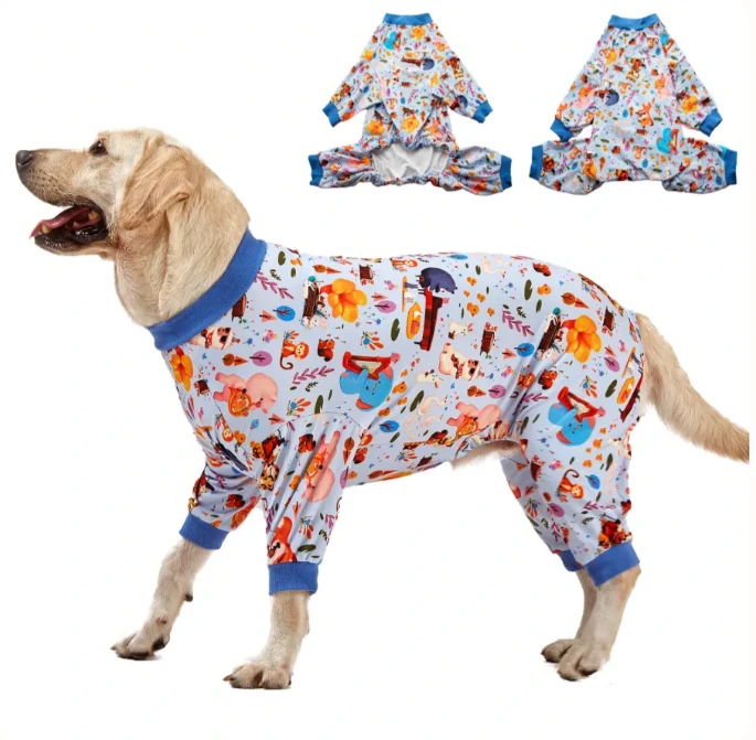 Labrador in autumn-themed pajamas with blue trim, showing cozy woodland and animal designs, standing on white background.