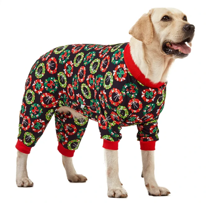 Labrador in black holiday pajamas with colorful Christmas wreaths, accented with red cuffs and collar, bringing festive charm.
