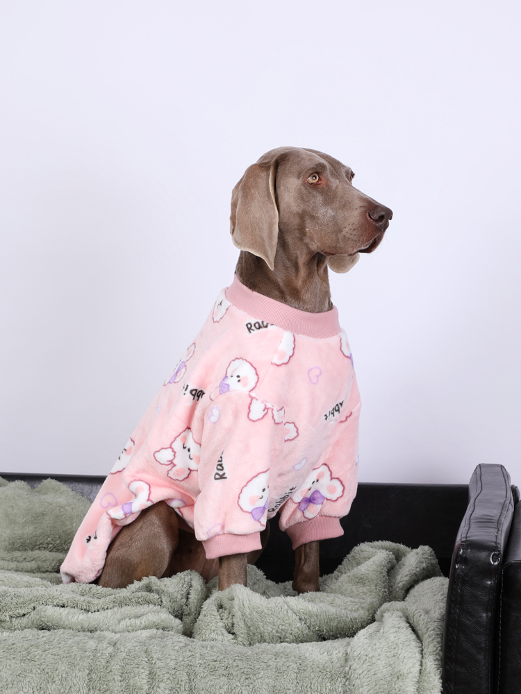 Large dog wearing Lovinpet pink fleece pajamas with a cute design, sitting comfortably on a green blanket, perfect for providing warmth and comfort.