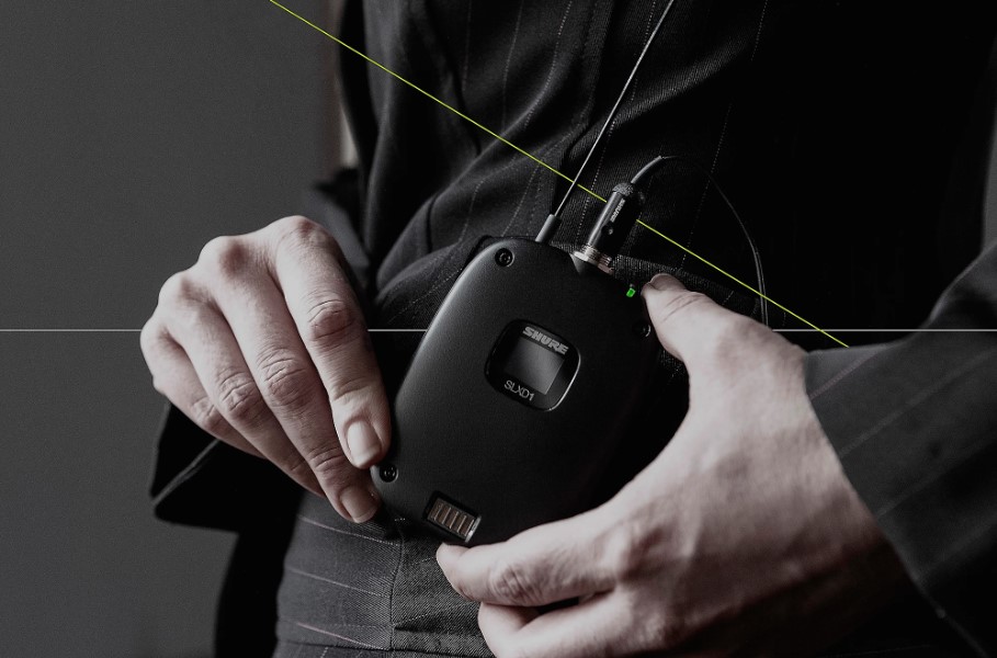 man holding Shure SLXD15 wireless system with transmitter 