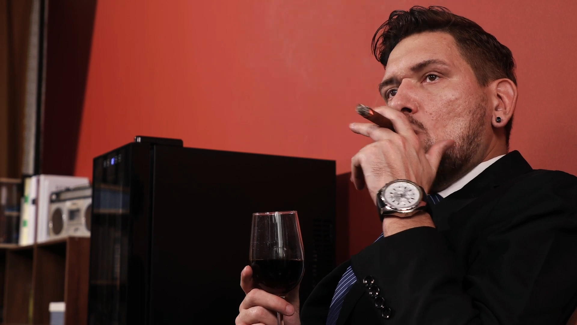 Man savoring a perfectly preserved cigar, well-protected by Mojgar's Electric Cigar Humidor.