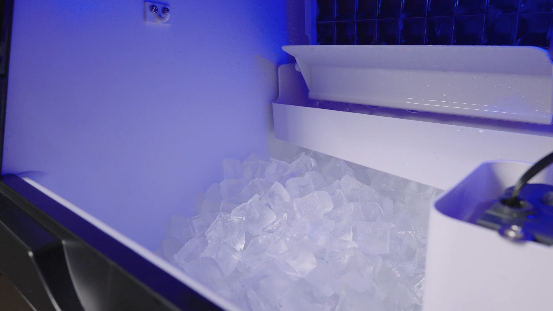 Clean ice maker storage bin filled with clear ice cubes