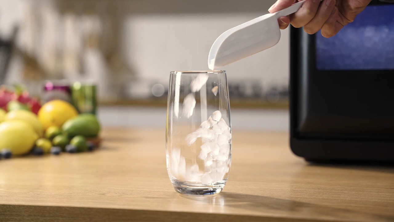 Scooping chewable nugget ice from Mojgar ice maker into a glass