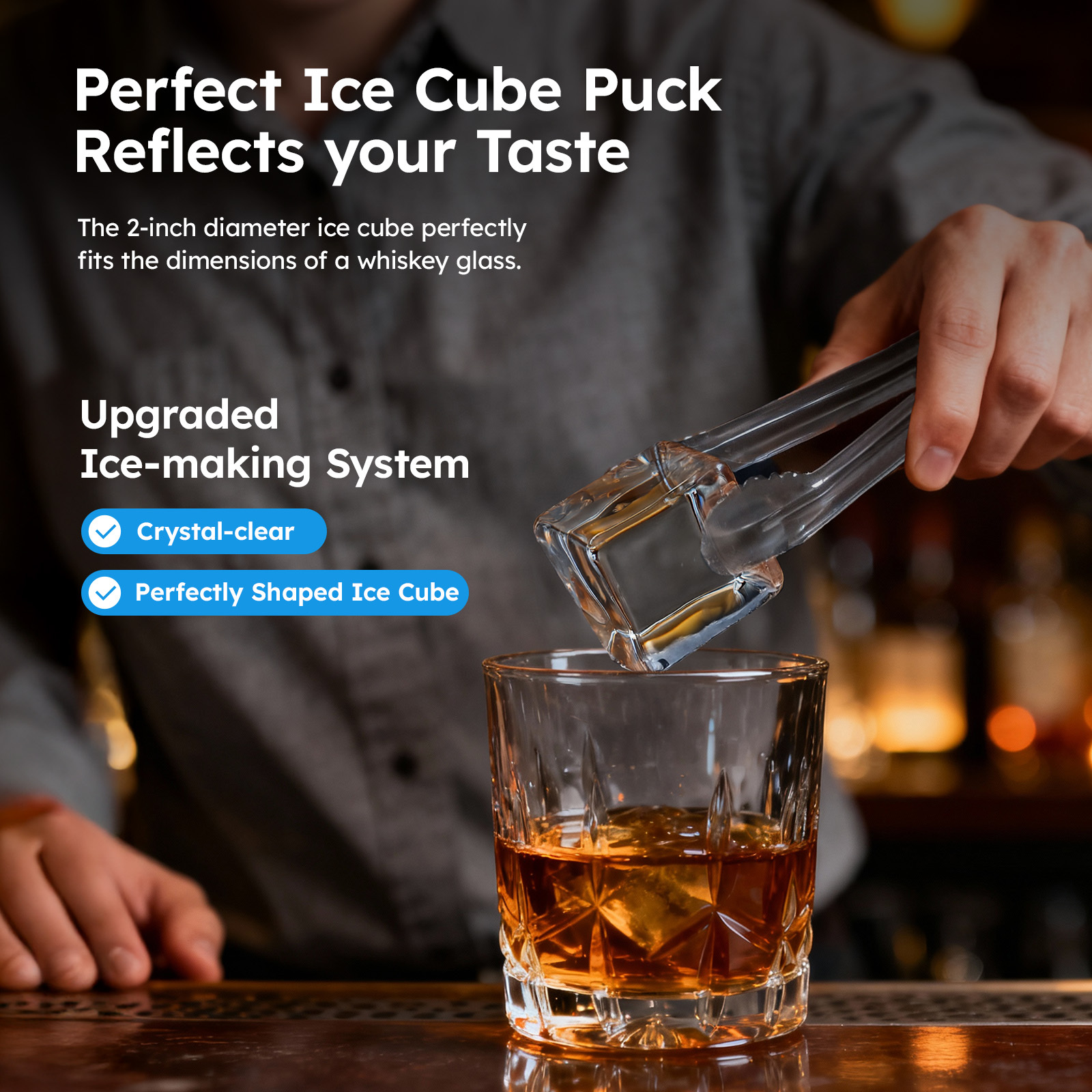 Mojgar 2 inch clear ice cube being added to whiskey with tongs, showcasing crystal-clear, perfectly shaped ice cubes for cocktails, whiskey, and home bar, highlighting upgraded ice-making system and premium drinking experience.