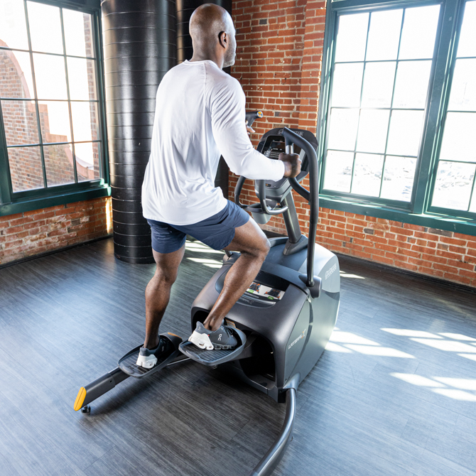 Man using lateral elliptical - rear view