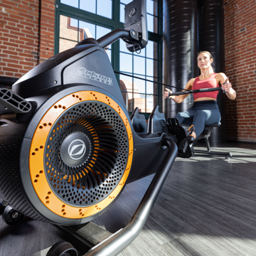 Close up of base of Octane Ro rower with woman using it in distance