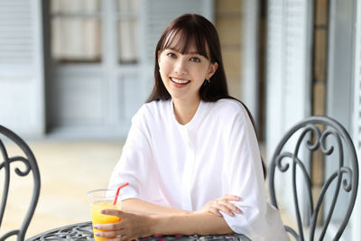 Person Sitting at a Coffee Table Drinking Orange Juice
