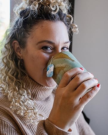 woman sipping numi aged earl grey tea