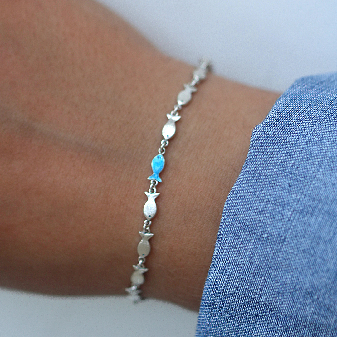Swimming Against The Current Fish With One Blue Bracelet