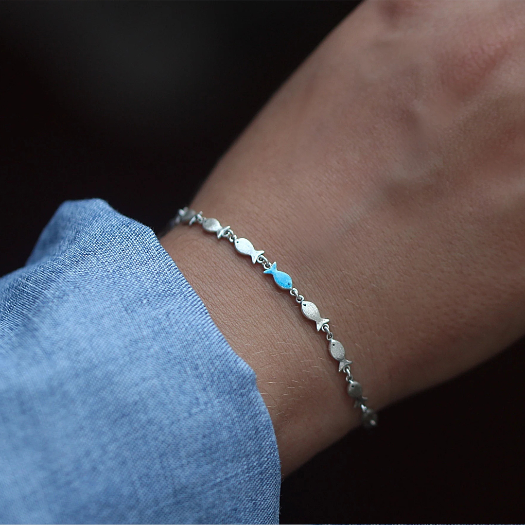 Swimming Against The Current Fish With One Blue Bracelet