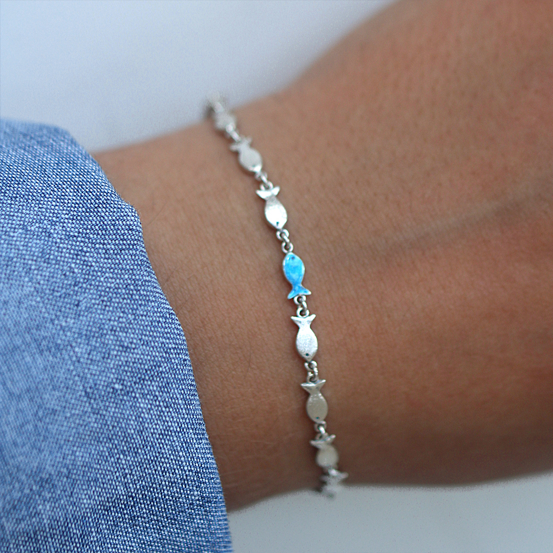 Swimming Against The Current Fish With One Blue Bracelet