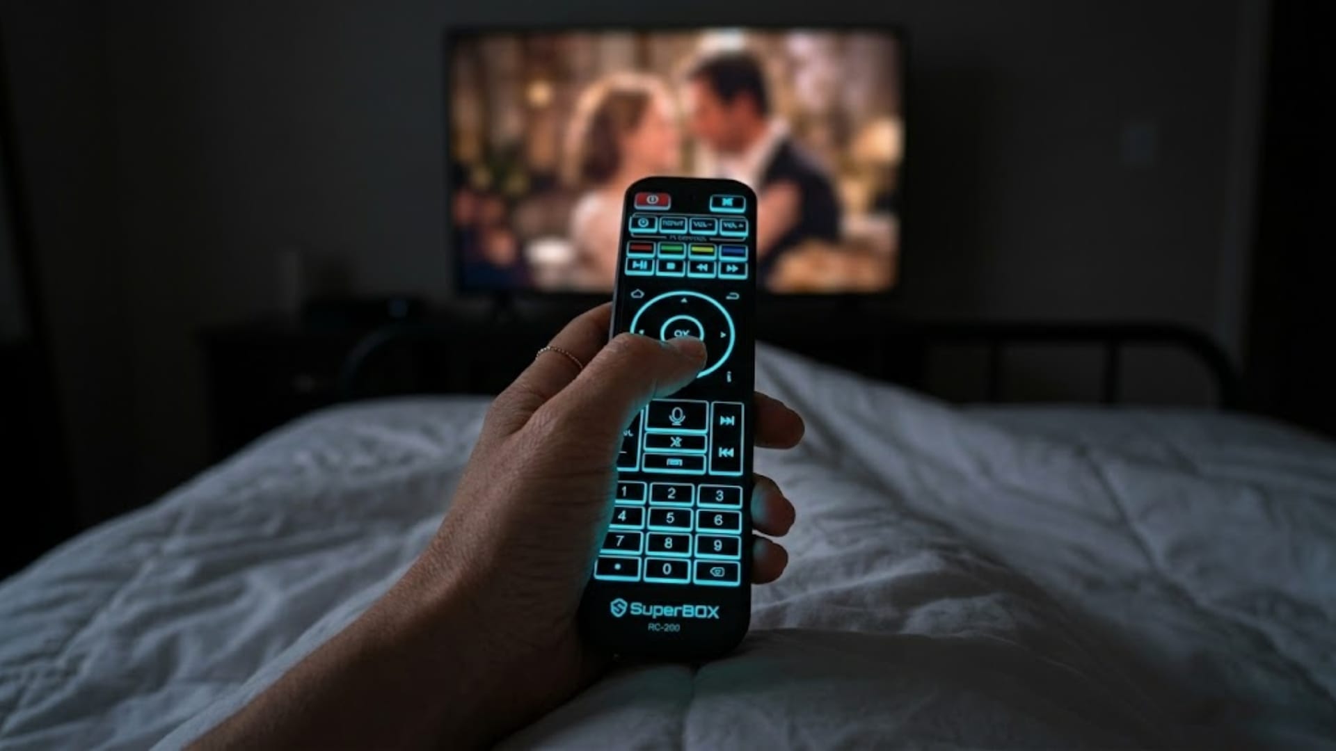 SuperBox S8 Ultra backlit voice remote in dark bedroom with glowing keys