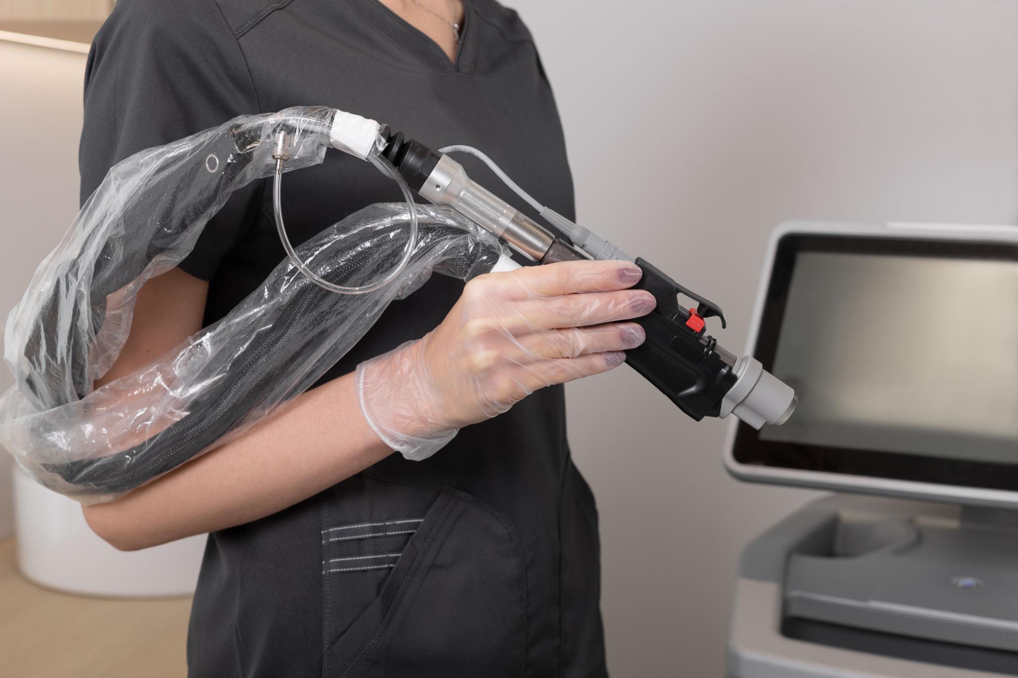 Cosmetologist set the options of laser hair removal machine before procedure