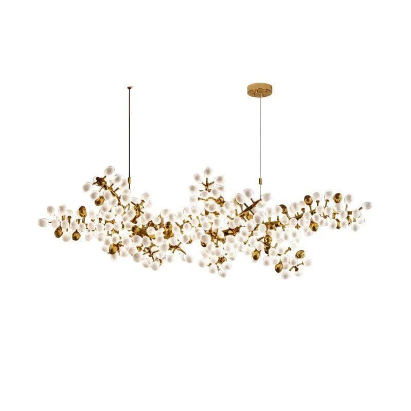 The Zylero Grapevine Chandelier, with its white backdrop, showcases a stunning interplay of light and shadow, highlighting the fixture's natural-inspired design and gold accents.