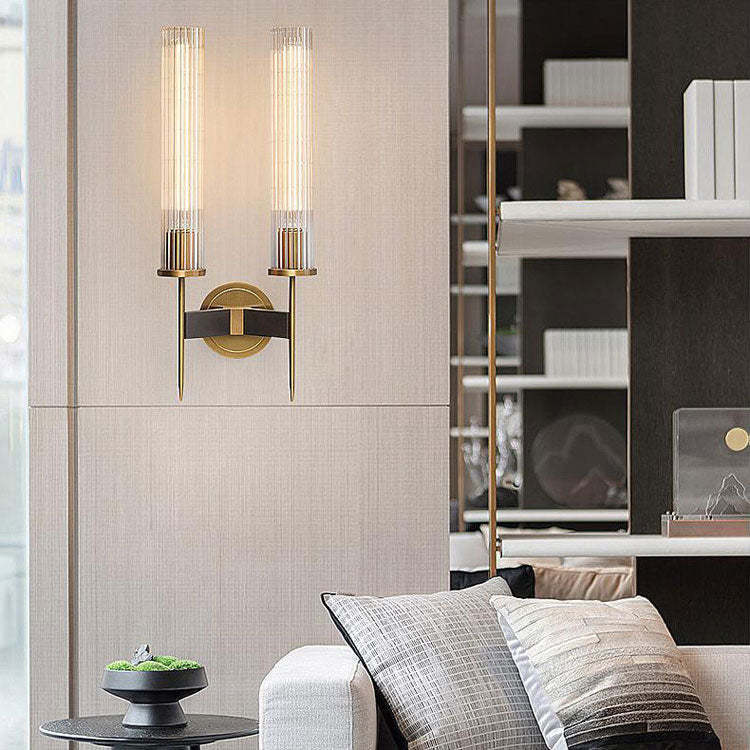 Sophisticated gold wall sconce with dual ribbed glass shades, adding a warm ambiance to a modern space