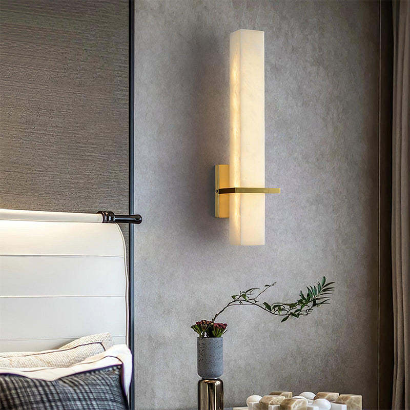 The Milan wall sconce provides soft lighting in the bedroom with its clean design and modern finishes.
