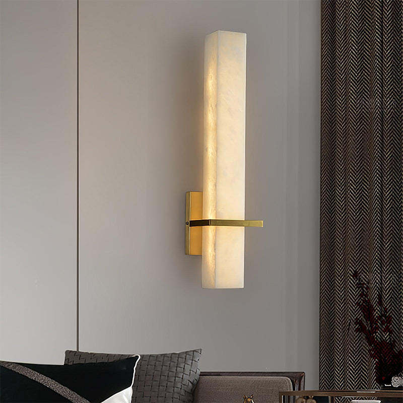 The Milan wall sconce adds a clean, modern touch to the living room with its sleek design and crystal-like outer shade.