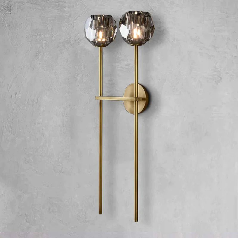 The Zylero Wall Sconce in gold infuses your living room with a warm radiance, its solid brass and crystal glass design creating a luxurious ambiance.