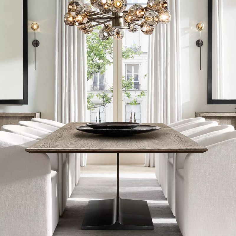 The brass and crystal chandelier adds a soft, warm glow to the dining room, creating a comfortable atmosphere for meals.