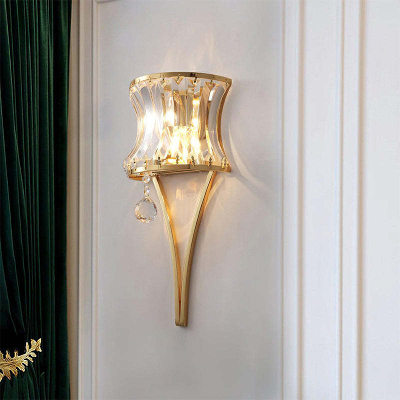 The wall sconce, with its curved glass panels, is installed on the living room wall, offering gentle illumination.
