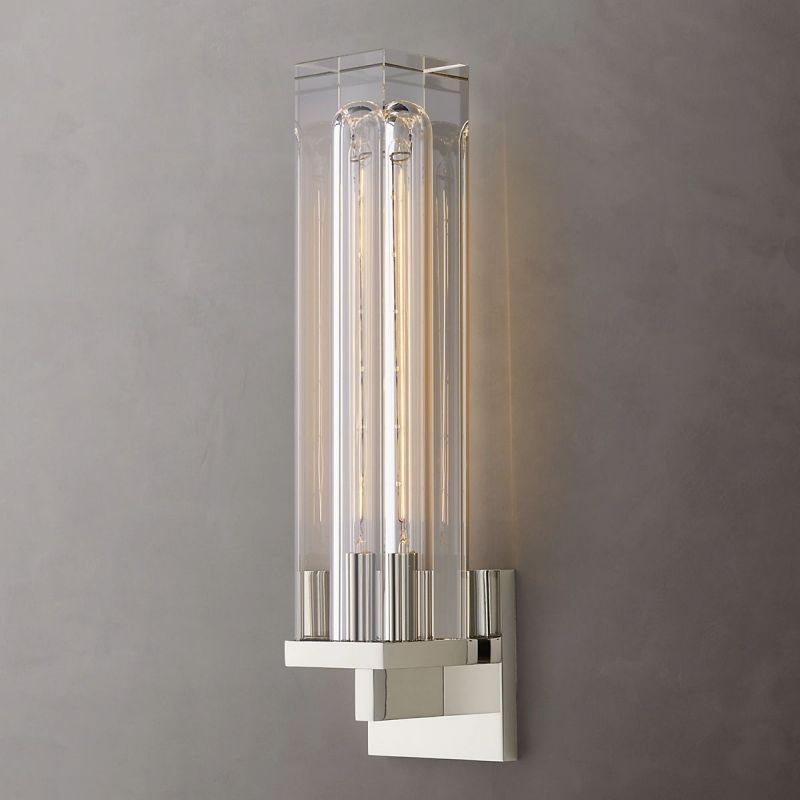The Zylero Savill Wall Lamp in silver brings a cool, contemporary feel, with its crystal block and brass frame creating a stunning light display.