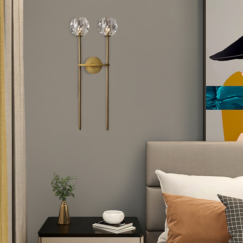 The Zylero Wall Sconce enhances your living room with a sophisticated glow, its solid brass and crystal glass design diffusing light for a warm and inviting atmosphere.