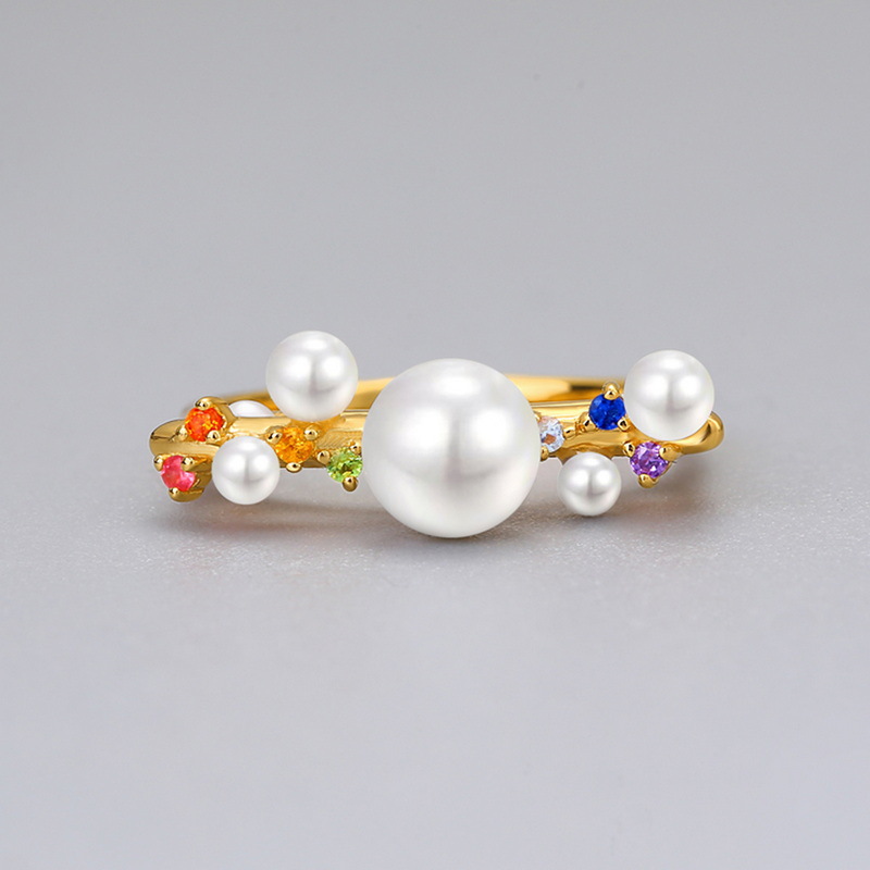 Woman’s hand wearing gold plated pearl and zircon ring