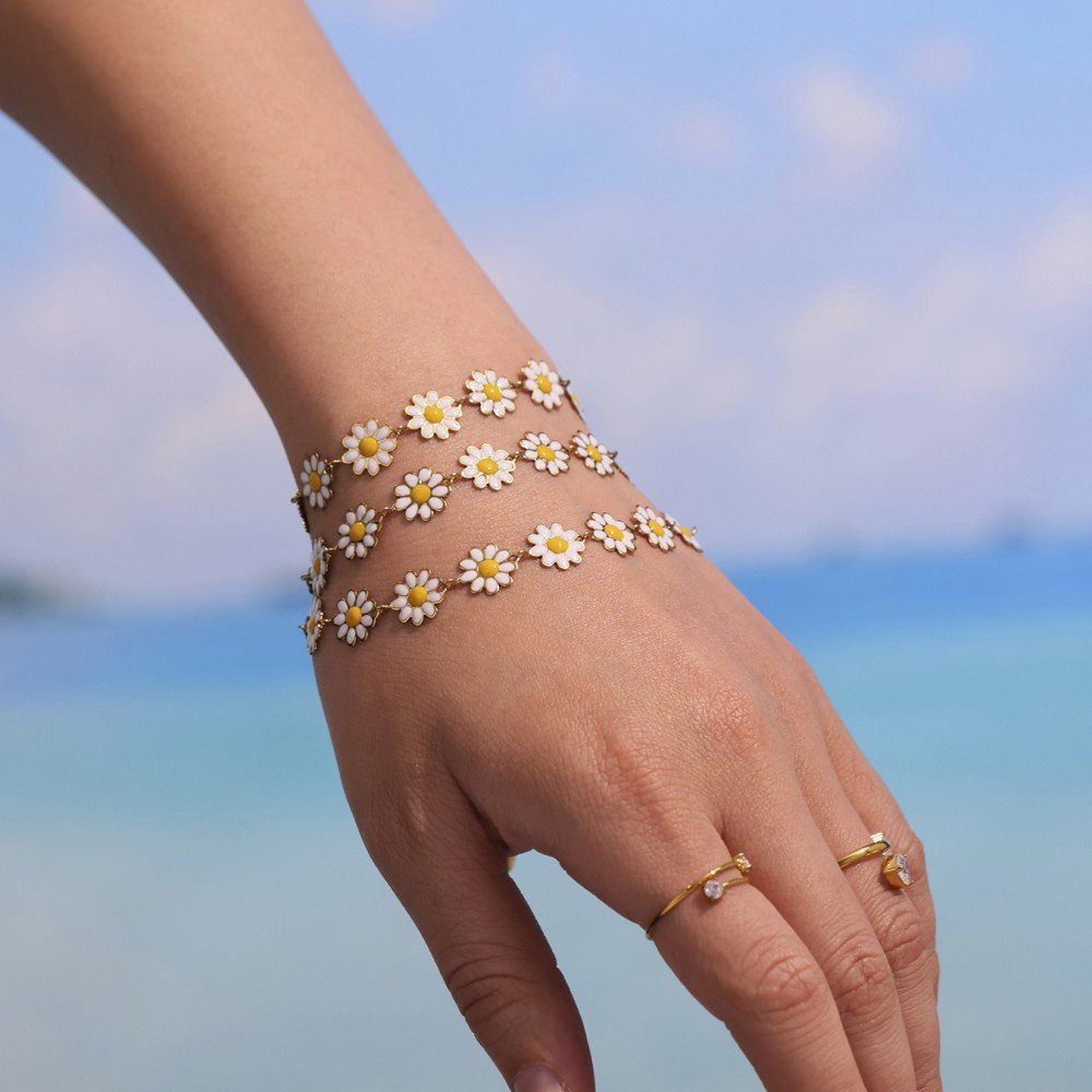 Close-up of daisy charm bracelet and anklet in modern jewelry fashion look