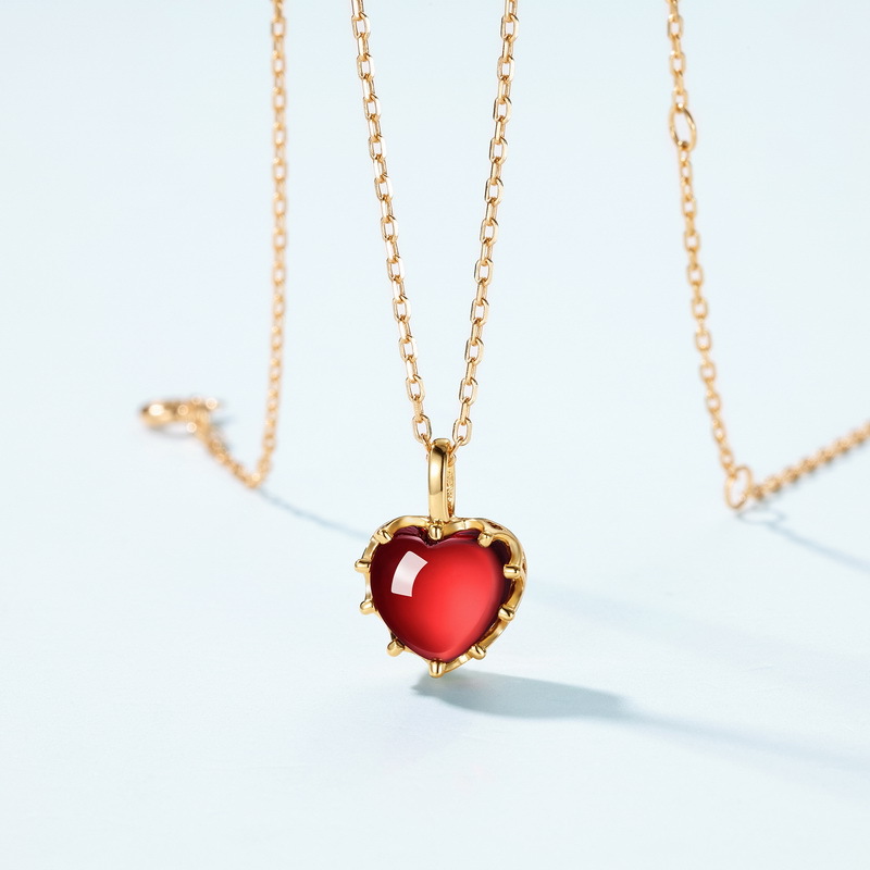 Garnet birthstone necklace layered with other gold jewelry
