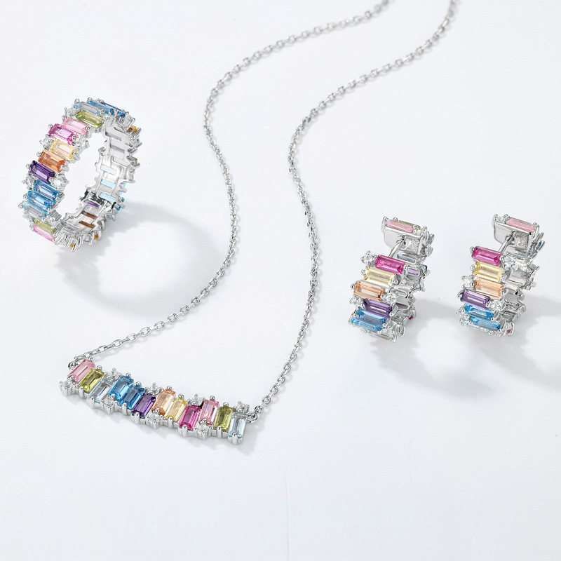 A vibrant display of colorful jewelry including rainbow rings, birthstone necklaces, and lab-grown gemstone earrings, arranged on a soft pastel background to evoke joy, diversity, and self-expression.