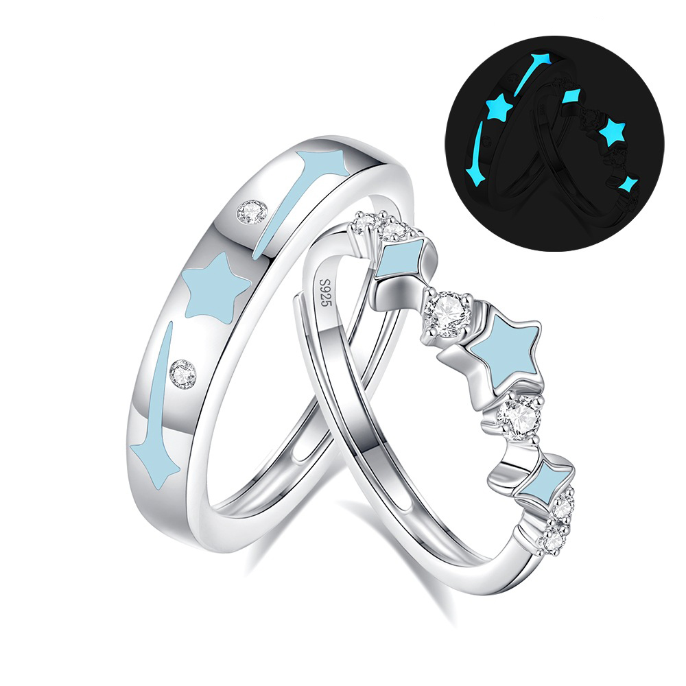 Matching couple rings glowing softly in the dark side by side