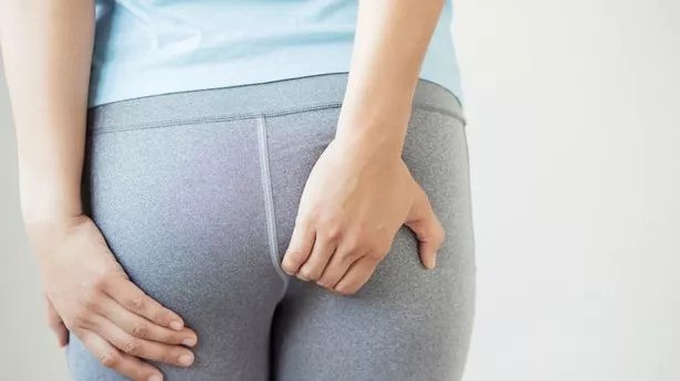 The StressNoMore Guide to Haemorrhoids-StressNoMore. Person in fitted clothing touching their buttocks, illustrating discomfort or itching commonly associated with haemorrhoids or anal irritation.