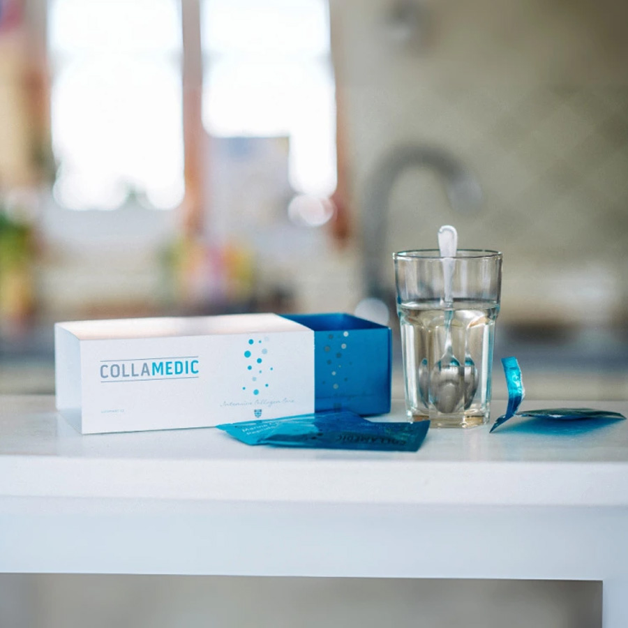 Collamedic Bioactive Marine Collagen drink prepared on a kitchen counter, showing collagen sachets, product box, and a glass of water with spoon, illustrating easy daily use of 5000 mg marine collagen for skin, hair, and nail support.