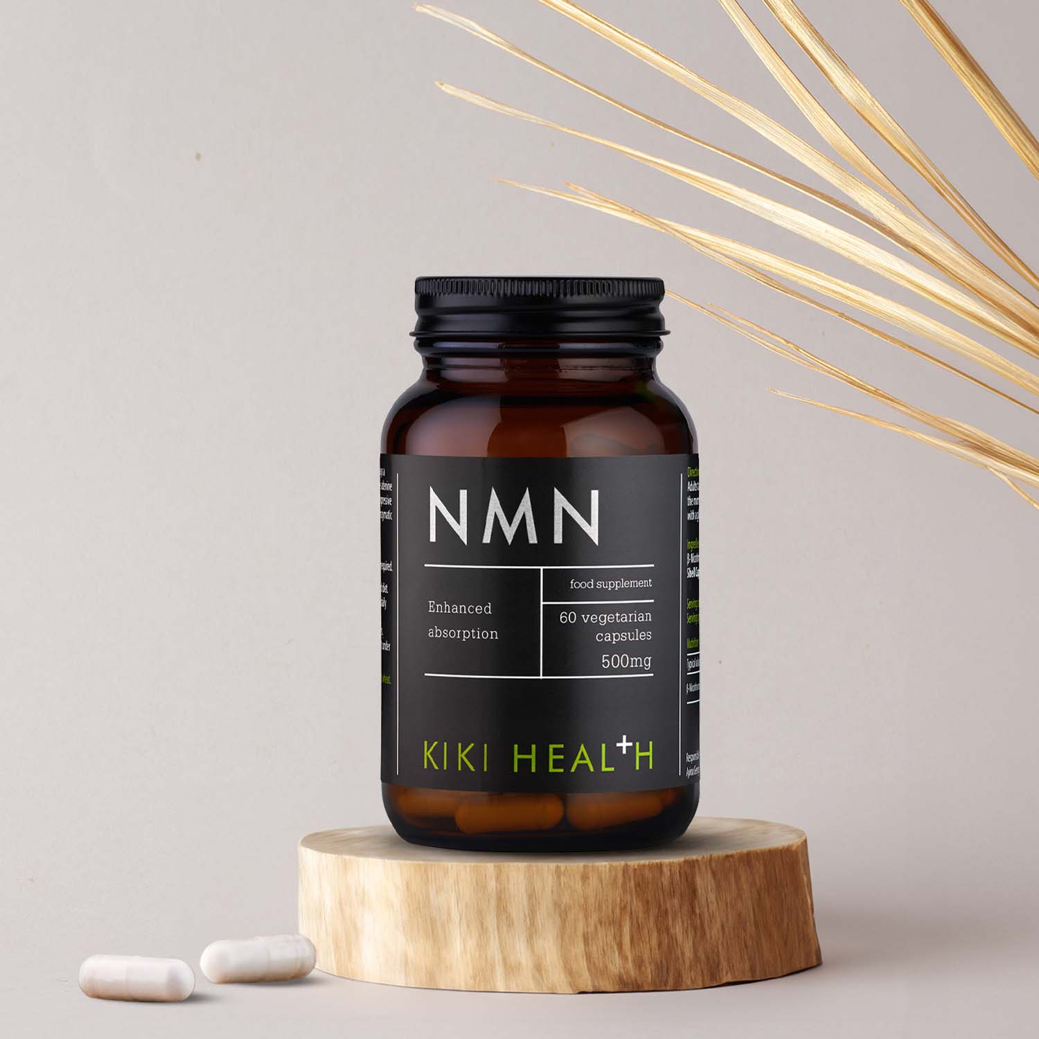 KIKI Health NMN supplement bottle on wooden plinth with capsules beside it, showcasing 500mg nicotinamide mononucleotide vegetarian capsules designed to support cellular energy and healthy ageing.